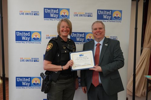 An award recipient accepts a certificate and flowers