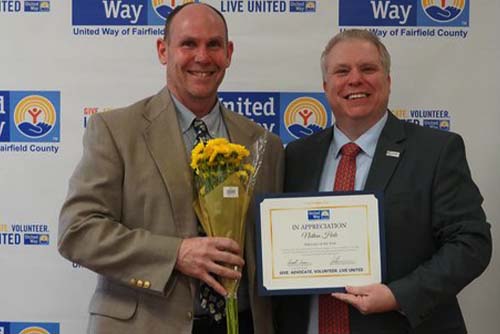 An award recipient accepts a certificate of appreciation