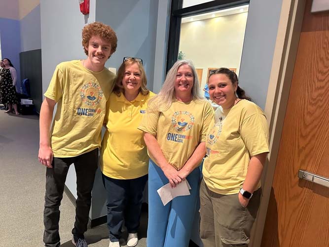 Four volunteers posing together in a hallway
