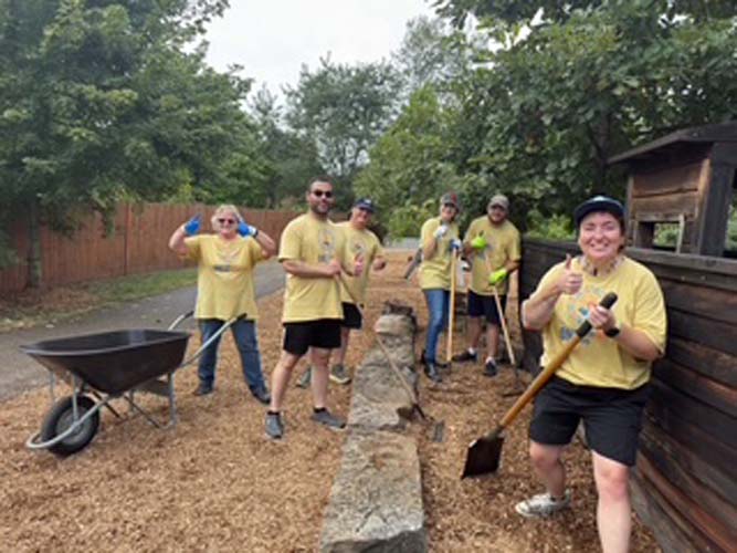 A crew giving thumbs up on the mulched playground path