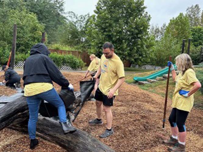 Volunteers moving landscape fabric at a playground project