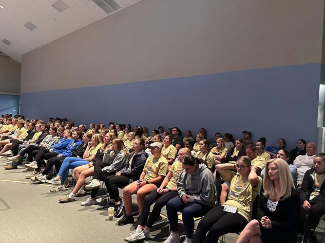 Rows of seated volunteers listening during the kick-off program