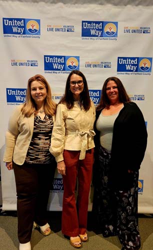 Three guests posing in front of the United Way step-and-repeat banner