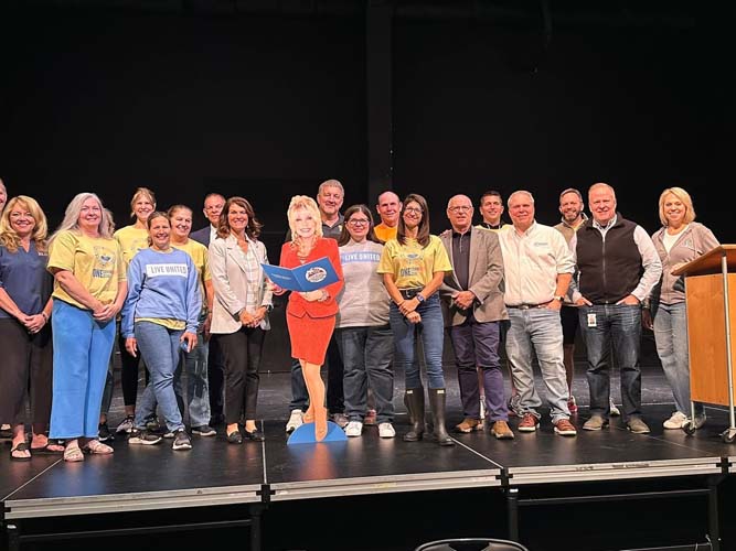 A large group of volunteers and community leaders on stage at the kick-off