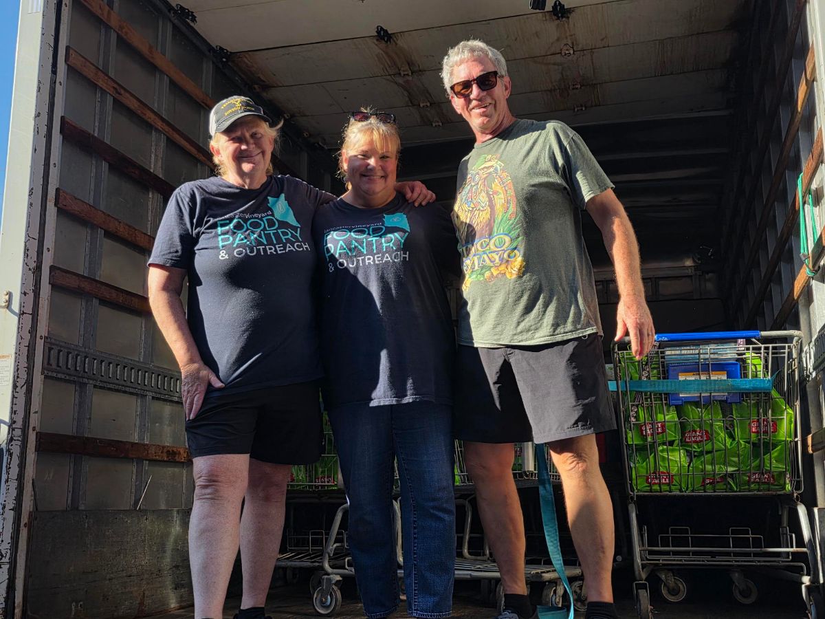 Three Lancaster Vineyard Food Pantry and Outreach volunteers in a delivery truck with carts of bagged food
