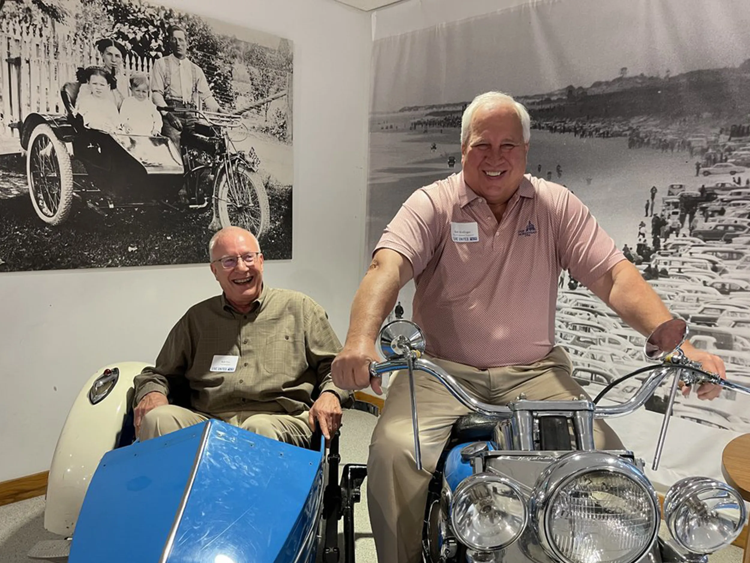 Two guests laughing on the motorcycle and sidecar display